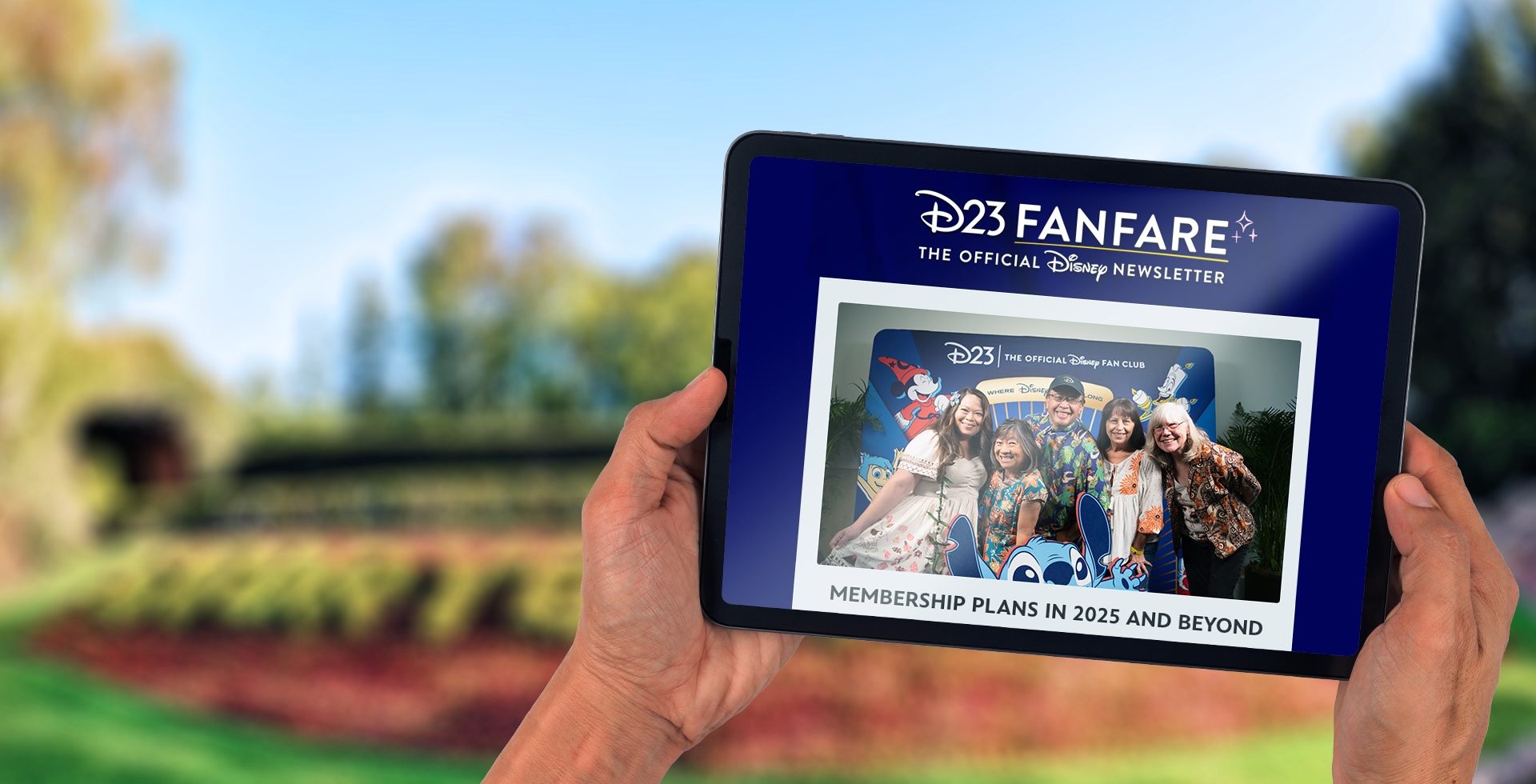 iPad - FanFare Hero Hands holding a tablet that has D23 FanFare pulled up, getting information on new Membership Plans.